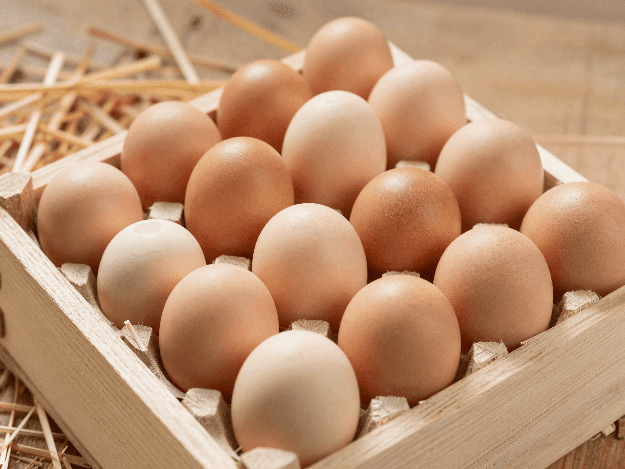 Uova fresche in cassetta di legno su paglia pulita