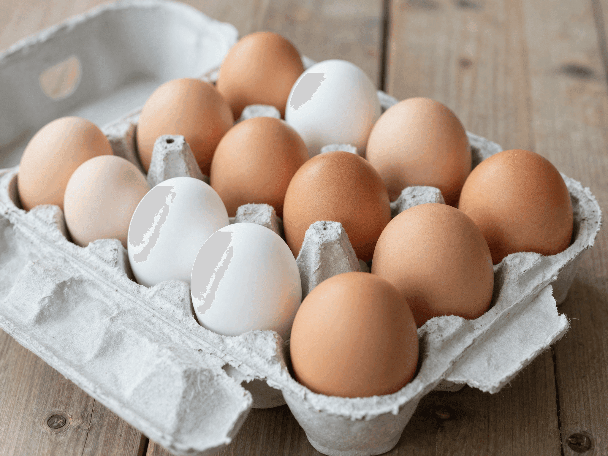 Dettaglio di uova fresche in confezione su tavolo rustico